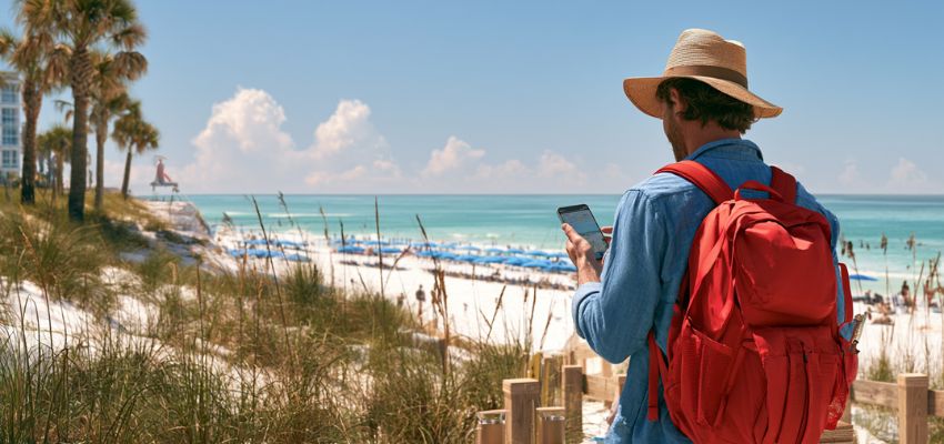 Traveler overlooking a lively shoreline while researching the best beach resorts in Florida.